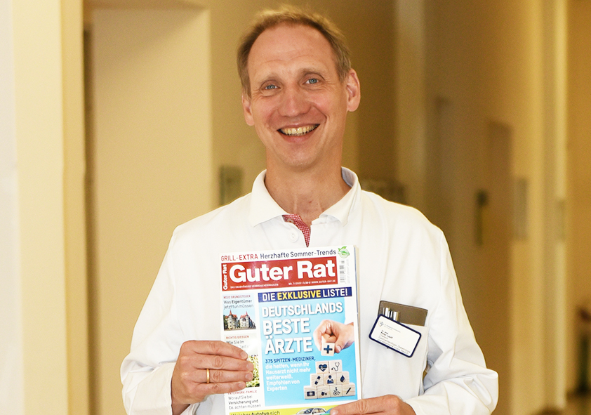 Dr. med. Peter Loeff zeigt ein Exemplar des Magazins "Guter Rat"