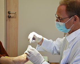 Chefarzt Dr. Peter Loeff untersucht einen Fuß mit Diabetischem Fußsyndrom