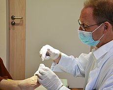 Chefarzt Dr. Peter Loeff untersucht einen Fuß mit Diabetischem Fußsyndrom