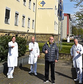 Das Ärzteteam der Klinik für Allgemein- und Viszeralchirurgie und ein genesener Patient präsentieren Kaugummistreifen