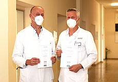 Dr. Jochen Hoffmann und Privat-Dozent Dr. Marcus Overhaus präsentieren die Urkunden für die besten Arbeitgeber